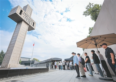 在侵华日军南京大屠杀遇难同胞纪念馆,人们在防空警报声中肃立默哀。苏 阳摄(新华社发)