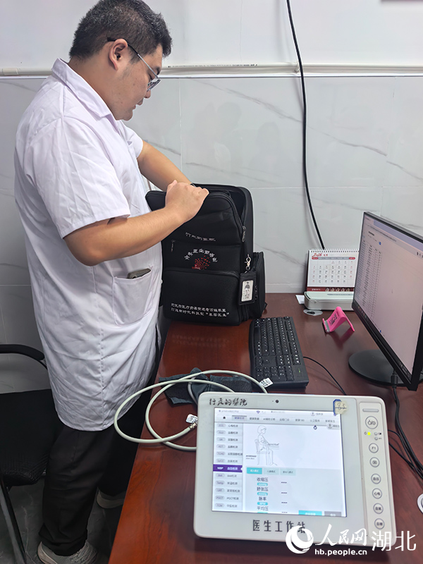 村医但梓良正在整理“全科医生助诊包”。人民网记者 周雯摄