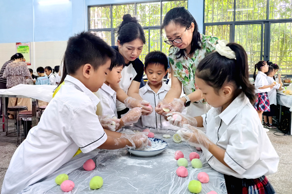 学生在家长代表的指导下做月饼。