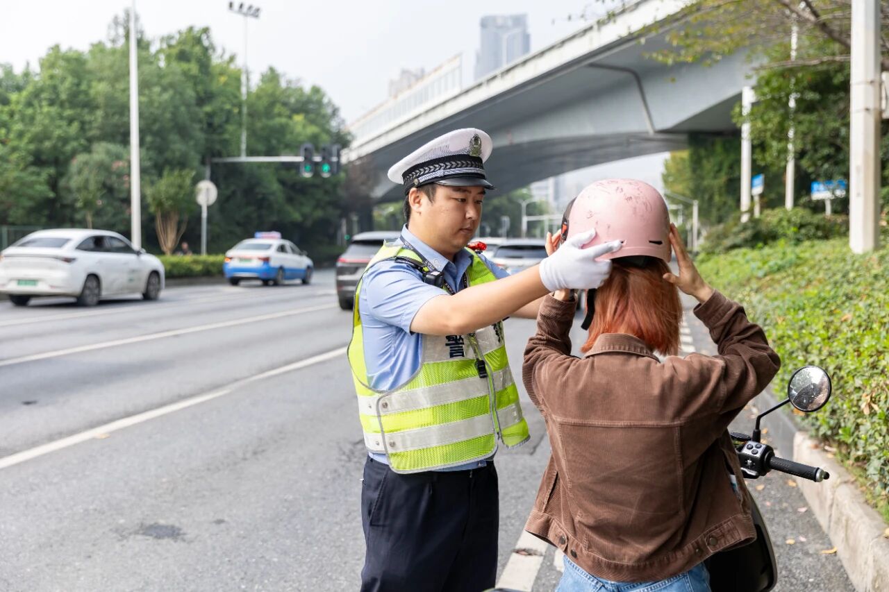陈浩引导电动自行车驾驶人正确佩戴头盔。