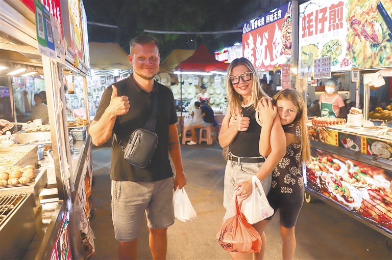 在三亚红旗街夜市,游客选购特色海鲜小吃。海南日报全媒体记者 王程龙 摄