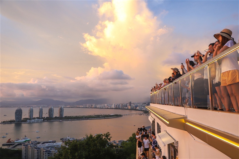 近日,游客来到鹿回头风景区欣赏三亚湾的海上晚霞。海南日报全媒体记者 王程龙 摄