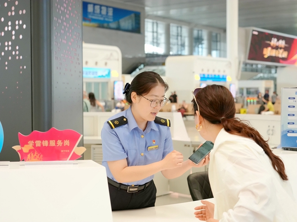 图为南宁东站客运值班员秦蓉蓉解答旅客问讯。麦竹娴摄