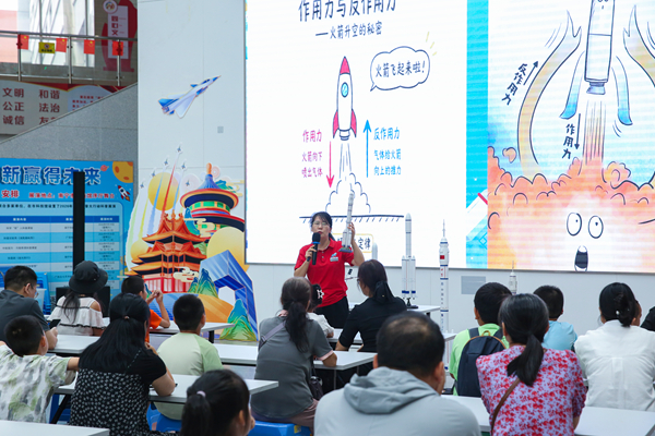科技辅导员在“梦启星河”活动中,向观众讲解火箭升空的科学原理