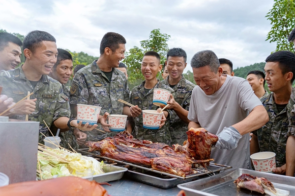图1为美食节现场,官兵围在餐台旁,脸上满是灿烂笑容。程博正摄