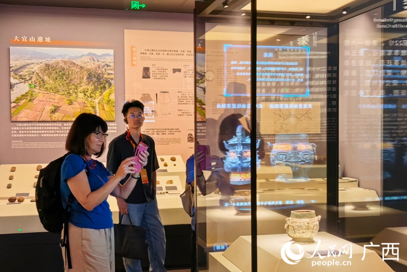在灵渠博物馆,外国宾客拍照打卡全息展柜。人民网 庞惠文摄