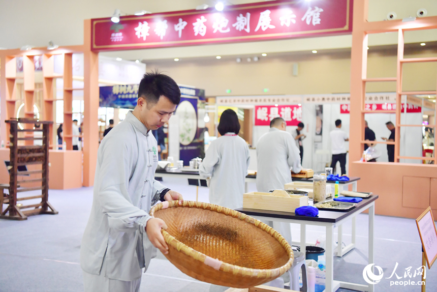 樟帮中药炮制技术展演现场，药工们用娴熟精湛的手法，为人们带来一场沉浸式中医药文化盛宴。人民网记者 时雨摄