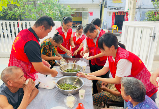 志愿者和长者一起包饺子。北海职业学院供图