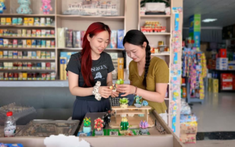 客户经理与零售户制作陈列摆件。