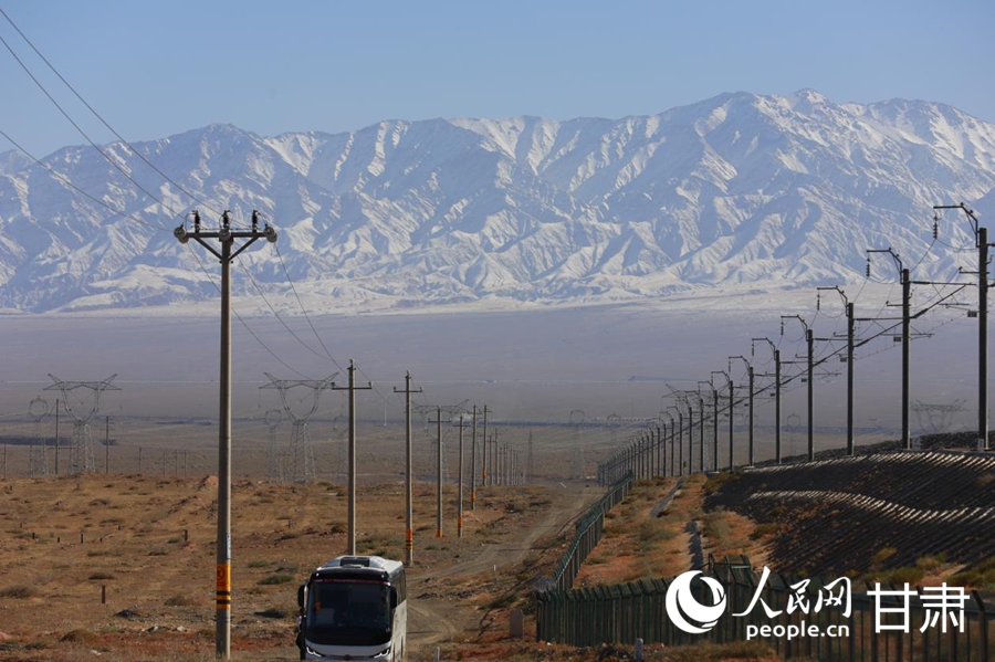 沙山沟铁路特大桥旁的公路,远处是连绵的阿尔金山。人民网记者 焦隆摄
