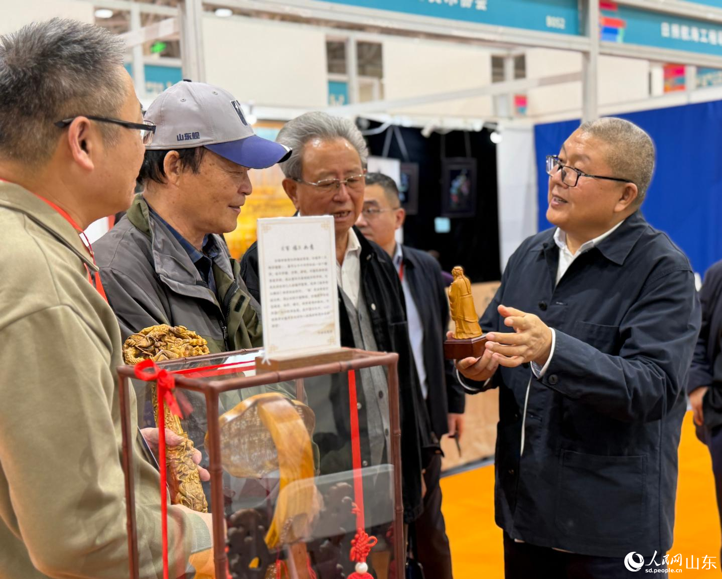 观展人在曲阜楷木雕展台前驻足。人民网记者 乔姝摄