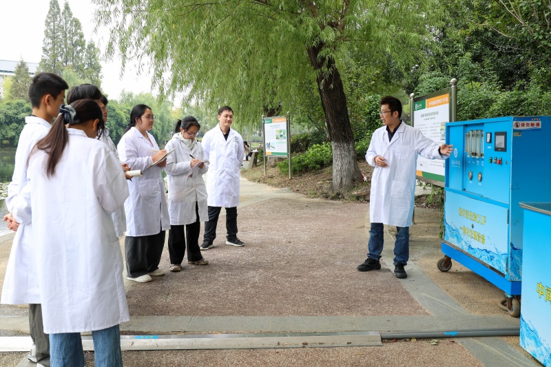 企业导师在校园水处理项目现场给老师和学生们讲解水处理设备的运行原理。芮雨欣摄