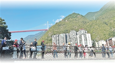 大渡河上，泸定桥游客拍照打卡。本报记者 游 仪摄